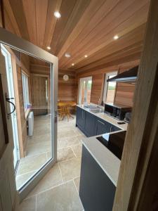 a kitchen with a glass door leading to a dining room at East Learmouth Lakeside Lodges - Larch Lodge in Cornhill-on-tweed