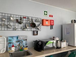 a kitchen counter with a sink and a microwave at Casanossa in Setúbal