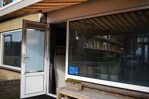 a screened in porch with a door and a window at ZeeBedStay in Noordwijk aan Zee