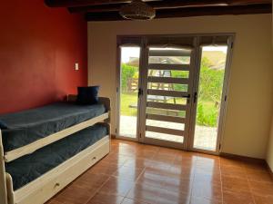 Habitación con cama y puerta corredera de cristal en Ayres de Cobo en Mar de Cobo