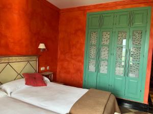 ヒメナ・デ・ラ・フロンテラにあるHotel Casa Henriettaのベッドルーム1室(ベッド1台付)、緑のキャビネットが備わります。