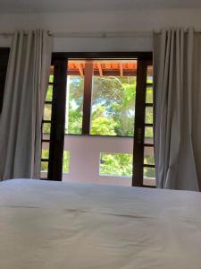 a bedroom with a bed and two windows at Princesinha do Sul in Ilhéus