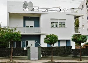 una casa blanca con árboles delante de ella en Zefyros Super Cool Apartments next to Alimos Riviera, en Atenas