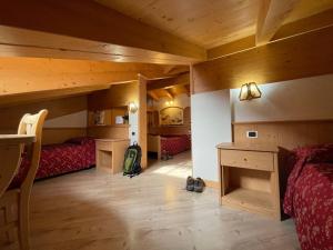 a bedroom with two beds and a desk in a room at Hotel San Lorenzo in San Lorenzo in Banale