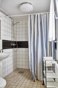 uma casa de banho com uma cortina de chuveiro e um lavatório em First Camp Sjöstugan - Älmhult em Älmhult