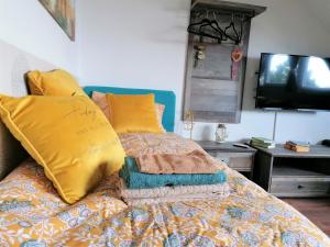 een bed met gele kussens en een tv in een kamer bij Jarun Apartman "Runolist" in Zagreb