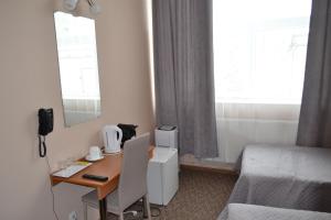 Habitación de hotel con escritorio, cama y habitación en Hotel Yes, en Narva-Jõesuu