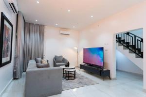 a living room with a couch and a flat screen tv at Palm Spring Luxury Apartment in Port Harcourt