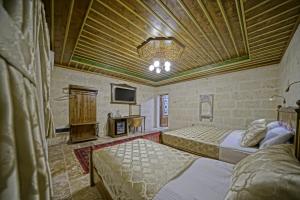 a bedroom with two beds and a chandelier at Zultanite Cappadocia Hotel in Nevşehir