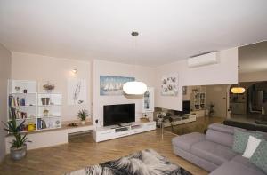 uma sala de estar com um sofá e uma televisão de ecrã plano em Apartment Rosi, surrounded by greenery in a quiet location em Pula