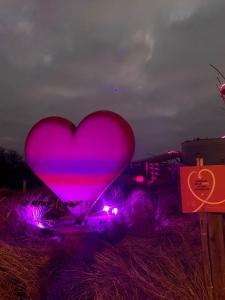 a pink heart sign in a field at night at studio Zeedijk Emperador in Middelkerke