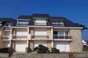 a large house with white doors and a roof at Sarzeau, st Jacques Vue pleine mer, possibilité nuitée in Sarzeau