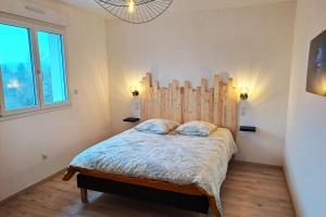 a bedroom with a bed with a wooden headboard at La KAVAL Vosgienne in Frémifontaine