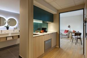 a kitchen with a sink and a counter top at Citadines Eurometropole Strasbourg in Strasbourg