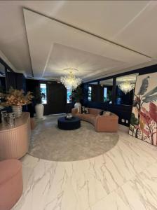uma ampla sala de estar com sofás e um lustre em Apartamento novo Gran Safira em Itapema