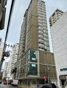 a tall building on the corner of a city street at Apartamento novo Gran Safira in Itapema