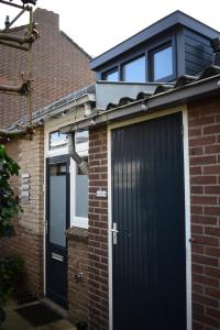 a detached house with a black garage and windows at ZeeBedStay in Noordwijk aan Zee