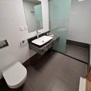 a bathroom with a toilet and a sink and a mirror at SPAR Furnished Hotel in Al Hofuf