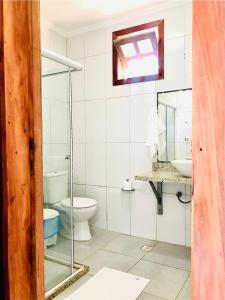 a bathroom with a toilet and a sink at Princesinha do Sul in Ilhéus