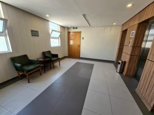 an empty waiting room with chairs and a door at SPAR Furnished Hotel in Al Hofuf