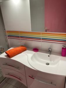 ein Badezimmer mit einem weißen Waschbecken mit einem Regenbogenstreifen in der Unterkunft Appartement proche des halles in Narbonne