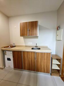 a kitchen with a sink and wooden cabinets at SPAR Furnished Hotel in Al Hofuf