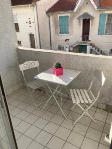 einen Tisch und Stühle auf einem Balkon mit einer Pflanze in der Unterkunft Appartement proche des halles in Narbonne