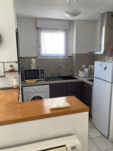 eine Küche mit einem weißen Kühlschrank und einer Spüle in der Unterkunft Appartement proche des halles in Narbonne