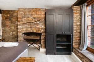 a bedroom with a brick fireplace and a bed at Highbury Corner in Bristol