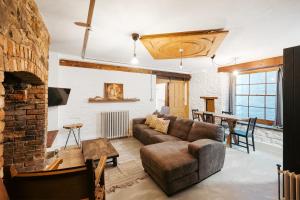 a living room with a couch and a brick fireplace at Highbury Corner in Bristol