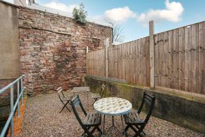 une table et des chaises devant un mur de briques dans l'établissement Highbury Corner, à Bristol