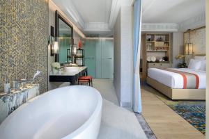 a bathroom with a tub and a bedroom with a bed at InterContinental Phuket Resort by IHG in Kamala Beach