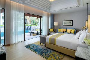 a bedroom with a large bed and a balcony at InterContinental Phuket Resort by IHG in Kamala Beach