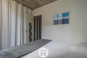 um quarto branco com uma cama e uma janela em R'Apparts Le Petit Grenoblois - Gare em Grenoble