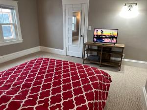 a bedroom with a red bed and a tv in it at The Uptown Oasis in Minneapolis