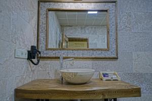 a bathroom with a bowl sink and a mirror at Zultanite Cappadocia Hotel in Nevşehir