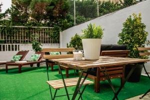 a patio with benches and a table with a potted plant at Real Beds Madrid in Madrid