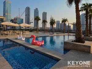 uma piscina com flamingos de brinquedo numa cidade em KeyOne - 1BR in Sparkle Tower no Dubai