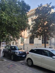 2 voitures garées sur un parking en face d'un immeuble dans l'établissement Il Re Dei Sogni, à Salerne