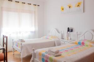 a bedroom with two beds and a window at Residencial Princesa do Ave in Vila do Conde