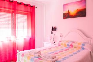 a bedroom with a white bed with pink curtains at Residencial Princesa do Ave in Vila do Conde