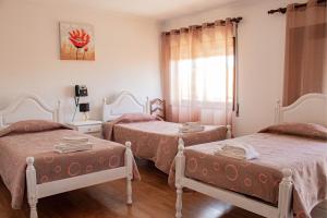 a bedroom with two twin beds and a window at Residencial Princesa do Ave in Vila do Conde