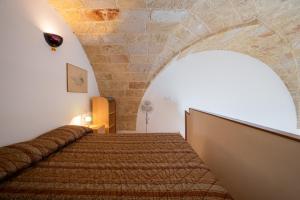 1 dormitorio con 1 cama con pared de ladrillo en Casa sul Mare - Tricase, en Marina Porto
