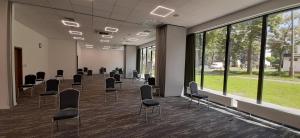 a conference room with chairs and large windows at Arche Residence Łódź in Łódź