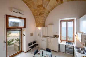 een keuken met een gewelfd plafond en uitzicht op de oceaan bij Casa sul Mare - Tricase in Marina Porto