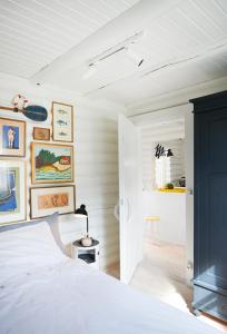 a bedroom with a white bed and some pictures on the wall at HAUS ZWEINEUN in Brodersby