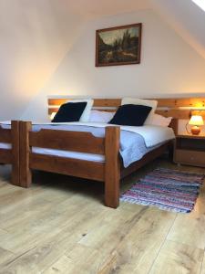 um quarto com uma grande cama de madeira e um tapete em Tatraview House em Veľká Lomnica