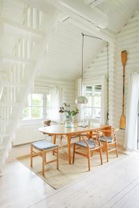 a dining room with a wooden table and chairs at HAUS ZWEINEUN in Brodersby