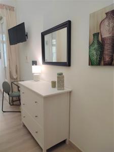 a white dresser with a mirror on a wall at Casa Decò Business Stay Solution in Taranto