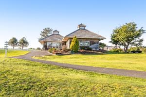 a house on a field with a road leading to it at Spruce Landing in Gearhart